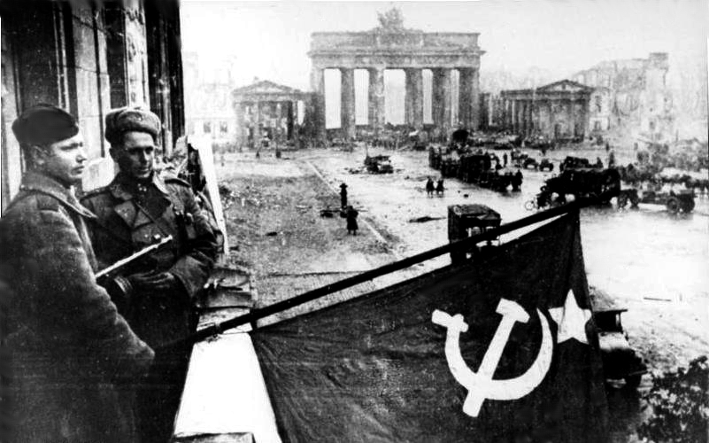 Al fondo, la puerta de Brandemburgo, mientras los soldados sovi&eacute;ticos ondean su bandera despu&eacute;s de la batalla de Berl&iacute;n, en mayo de 1945.