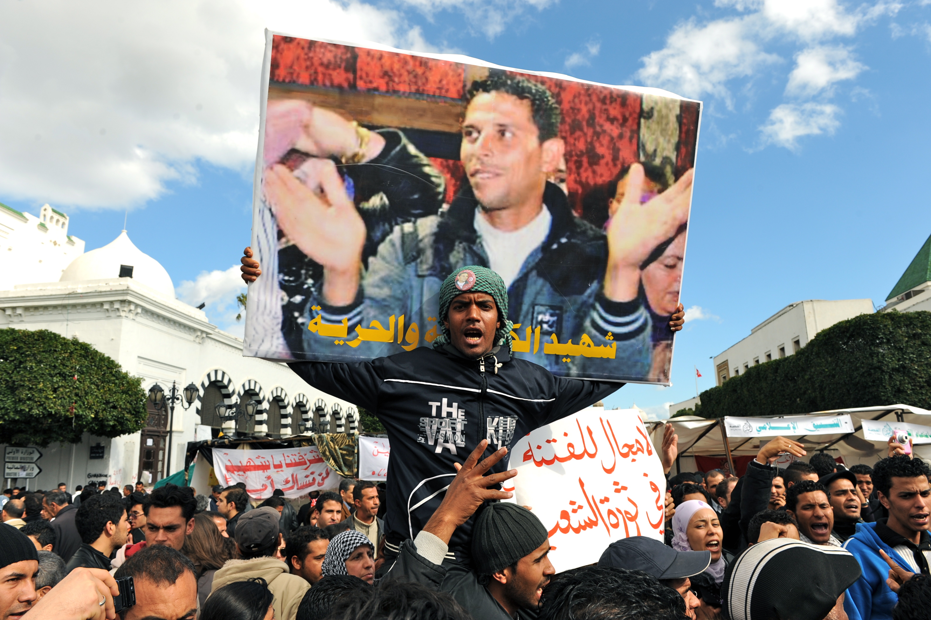 Manifestantes tunecinos protestan bajo un cartel de Mohamed Bouazizi en enero.